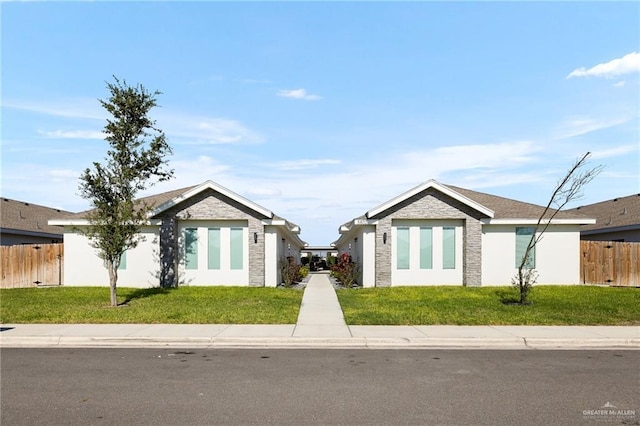 ranch-style house featuring a front yard, fence, and stucco siding