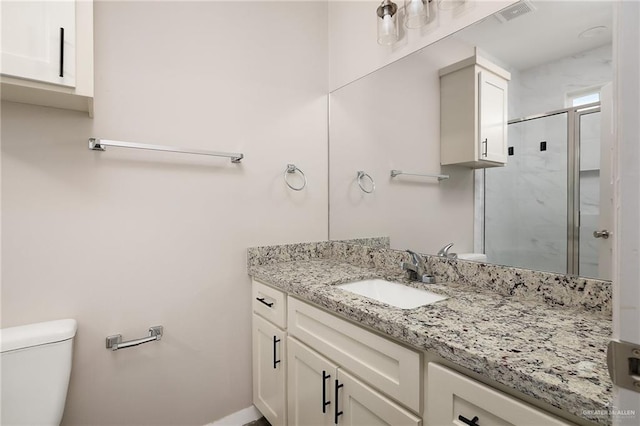 bathroom featuring toilet, a shower stall, visible vents, and vanity