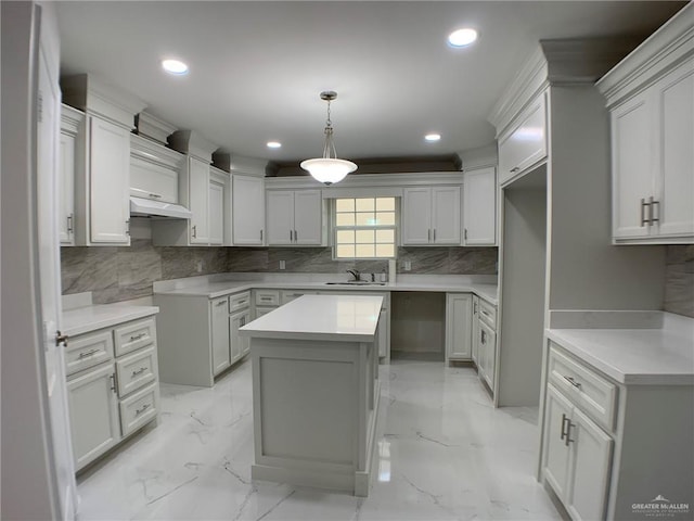 kitchen with a kitchen island, sink, tasteful backsplash, and decorative light fixtures