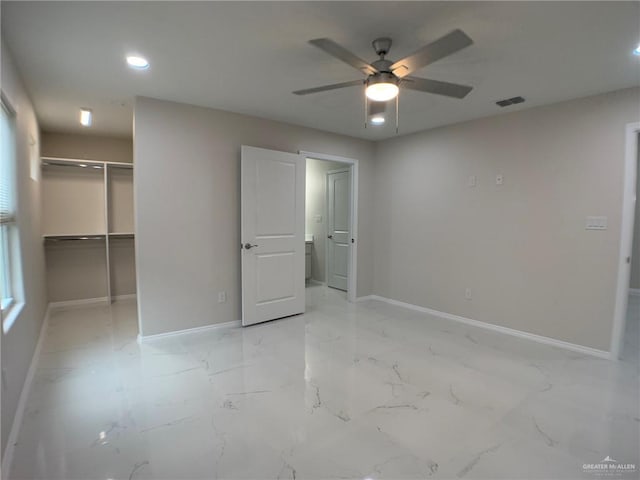 unfurnished bedroom with ceiling fan, a spacious closet, and a closet