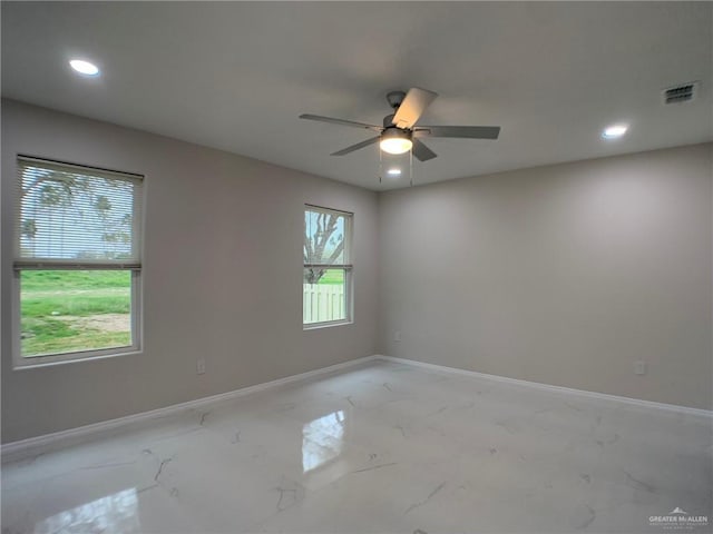 unfurnished room with ceiling fan and a wealth of natural light