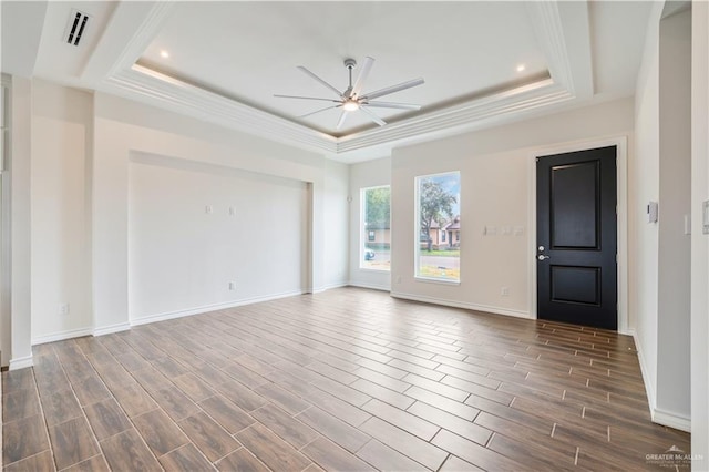 interior space featuring ceiling fan, visible vents, a raised ceiling, and wood finish floors