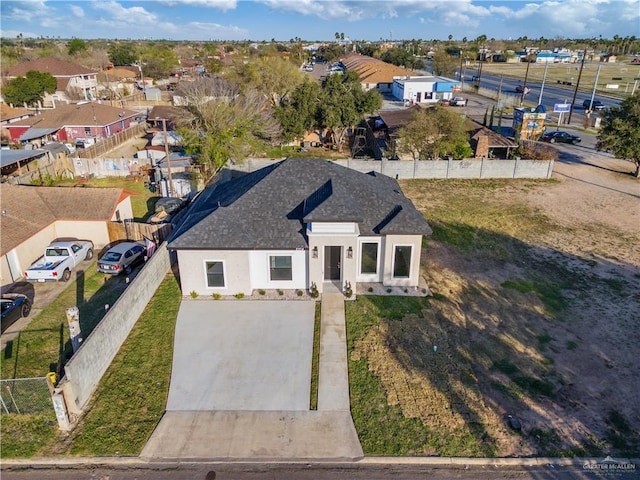 view of front of home with a residential view, roof with shingles, fence, and stucco siding