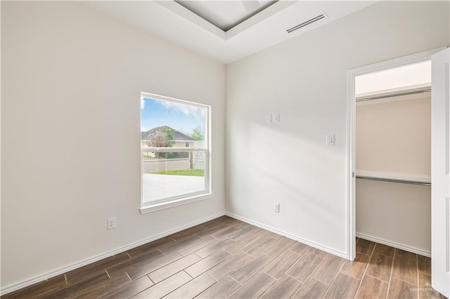 unfurnished bedroom with visible vents, a closet, and wood finish floors