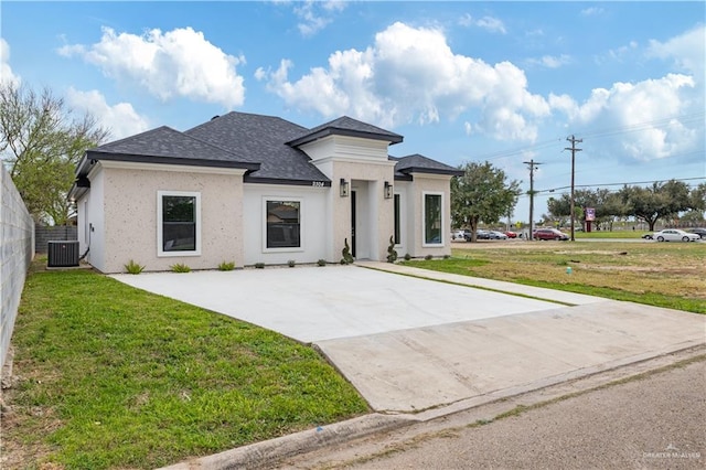 view of front of home featuring central air condition unit, a shingled roof, fence, stucco siding, and a front lawn