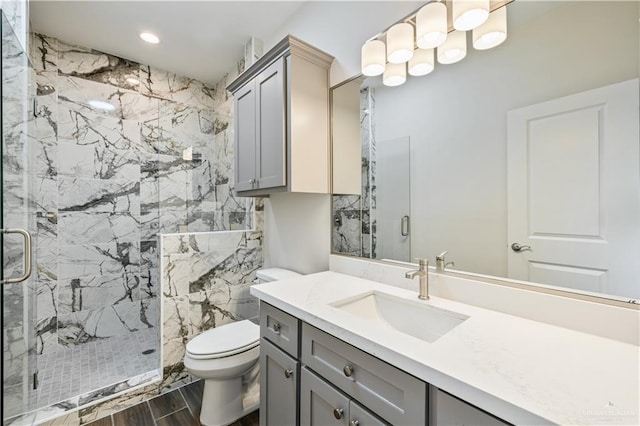 full bath featuring a marble finish shower, toilet, wood tiled floor, vanity, and recessed lighting