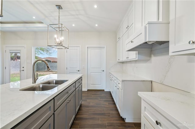 kitchen featuring dark wood finished floors, tasteful backsplash, recessed lighting, gray cabinetry, and a sink