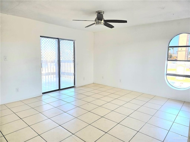 unfurnished room with light tile patterned floors, a healthy amount of sunlight, and ceiling fan