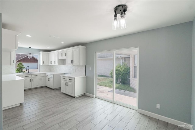 kitchen featuring white cabinets, plenty of natural light, decorative backsplash, and sink