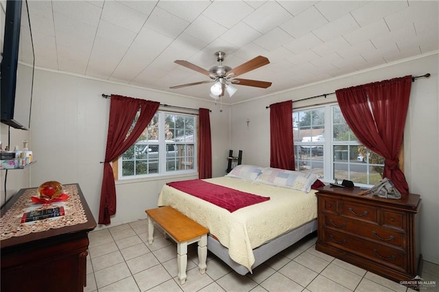 tiled bedroom with ceiling fan, ornamental molding, and multiple windows