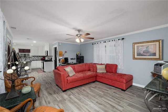 living room featuring ceiling fan, ornamental molding, and light hardwood / wood-style flooring