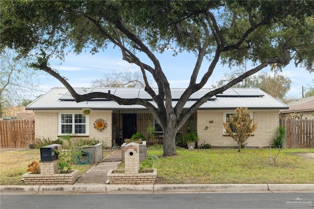 ranch-style house with a front lawn and solar panels