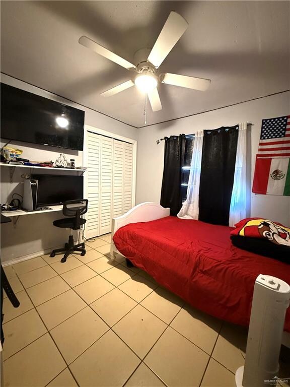 bedroom with ceiling fan, a closet, and light tile patterned flooring