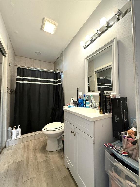 bathroom with vanity, toilet, wood-type flooring, and walk in shower