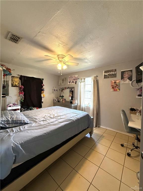 bedroom with light tile patterned floors, a textured ceiling, and ceiling fan