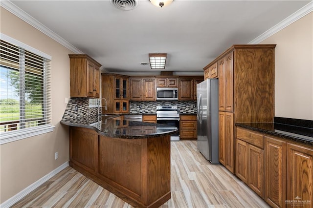 21890 Fm 508, Harlingen, TX 78550 - kitchen with stainless steel appliances, a peninsula, light wood-type flooring, tasteful backsplash, and brown cabinetry