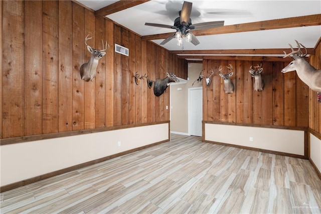 21890 Fm 508, Harlingen, TX 78550 - spare room featuring wooden walls, beamed ceiling, a ceiling fan, and light wood finished floors