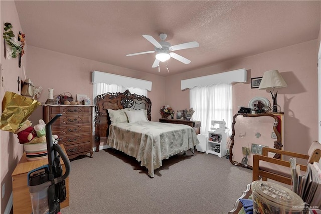 carpeted bedroom featuring a textured ceiling and ceiling fan