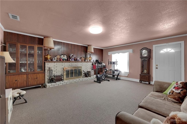 exercise area with carpet, a brick fireplace, a textured ceiling, crown molding, and wood walls