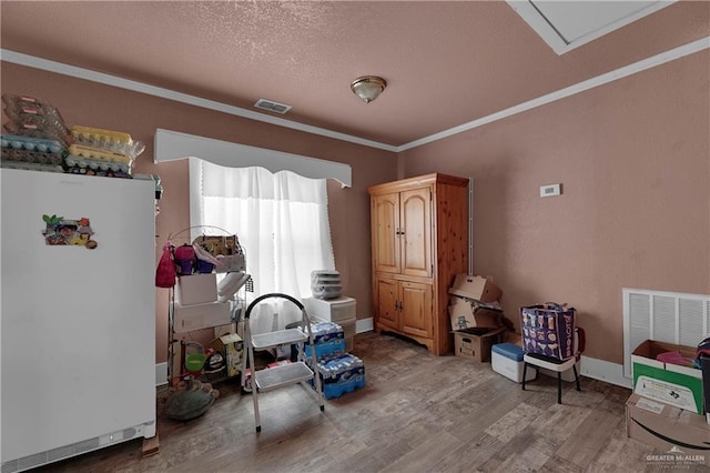 interior space with crown molding, wood-type flooring, and a textured ceiling