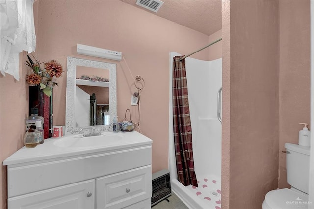 bathroom featuring a textured ceiling, vanity, toilet, and walk in shower