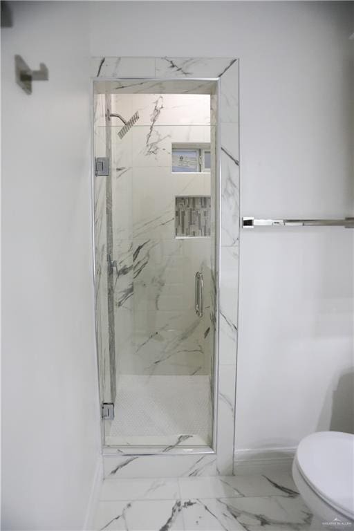 bathroom featuring toilet and a shower with shower door