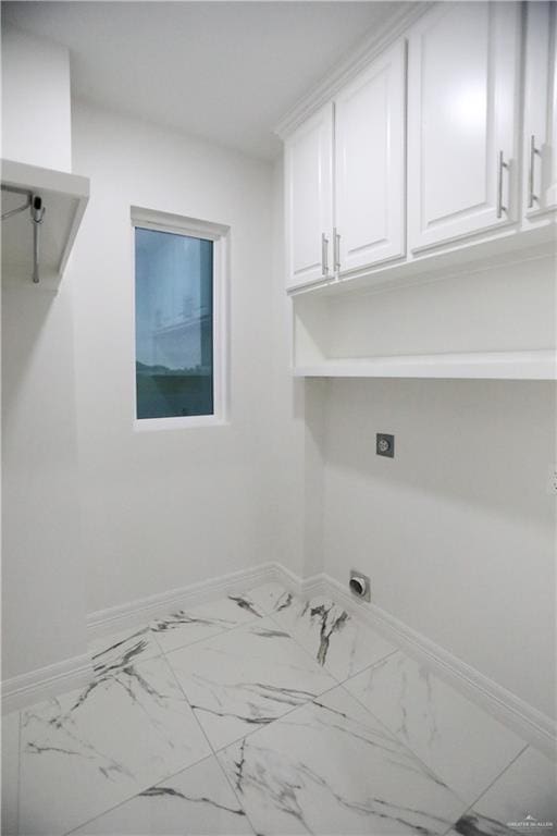 clothes washing area featuring electric dryer hookup and cabinets