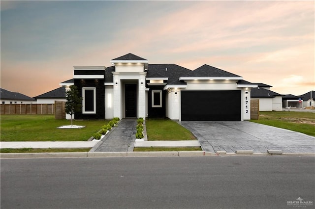 prairie-style home featuring a garage and a yard