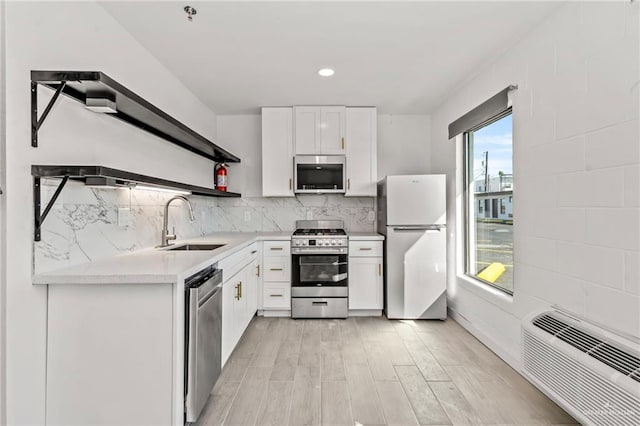 kitchen featuring plenty of natural light, stainless steel appliances, white cabinets, and sink