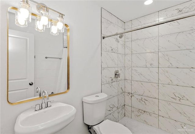 bathroom featuring sink, toilet, and tiled shower