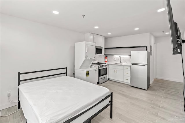 bedroom featuring white fridge, fridge, and sink