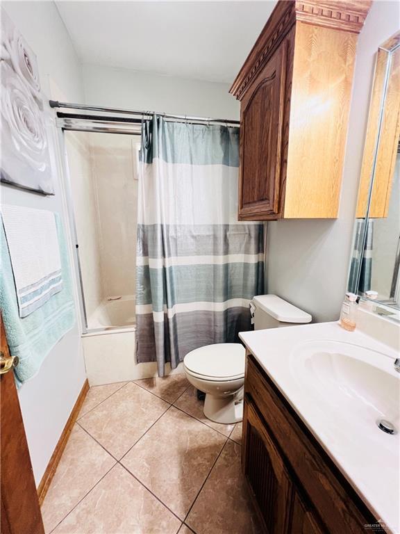 full bathroom featuring tile patterned floors, vanity, shower / bathtub combination with curtain, and toilet