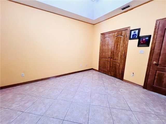 unfurnished bedroom with baseboards, visible vents, and light tile patterned floors