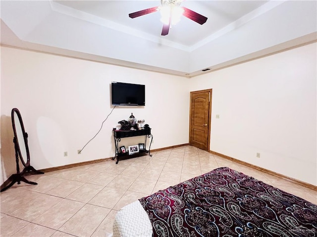 bedroom featuring light tile patterned flooring, a raised ceiling, visible vents, and a ceiling fan