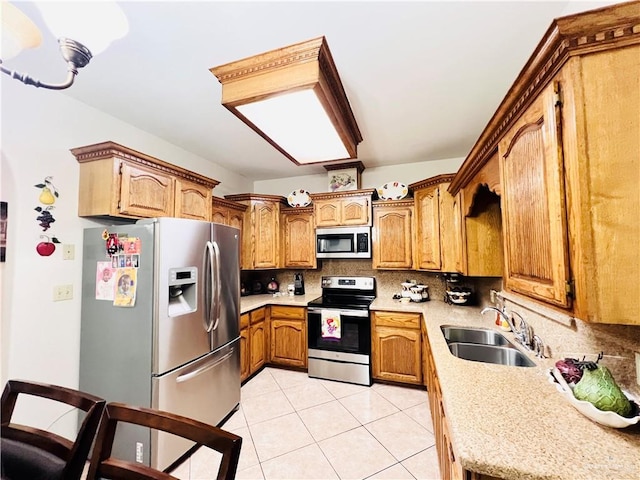 kitchen featuring backsplash, appliances with stainless steel finishes, a sink, and light countertops