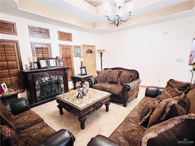 living area with an inviting chandelier, a raised ceiling, and light tile patterned floors