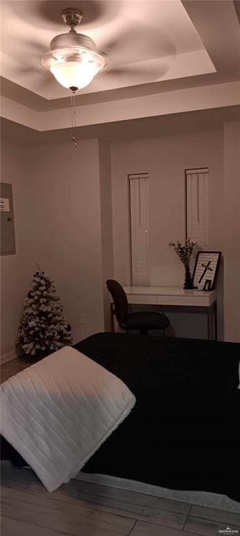 bedroom featuring ceiling fan and a raised ceiling