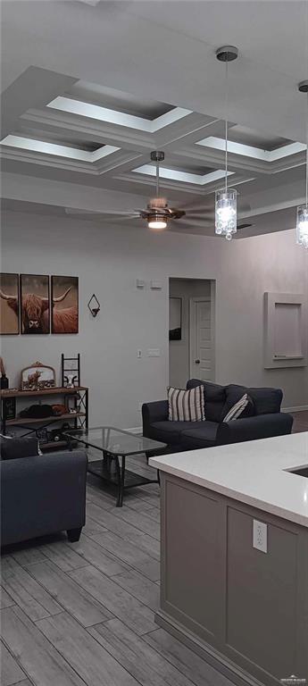 living room featuring coffered ceiling and light wood-type flooring