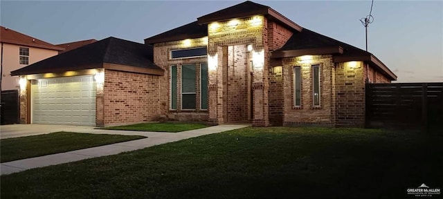 view of front of home with a garage and a lawn