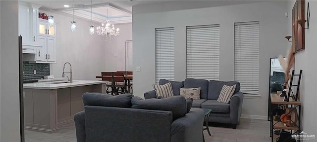 living room with sink, a notable chandelier, and light hardwood / wood-style floors