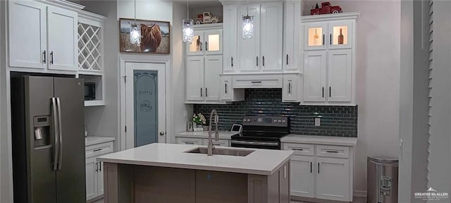 kitchen featuring pendant lighting, white cabinetry, stainless steel fridge with ice dispenser, electric stove, and a kitchen island with sink