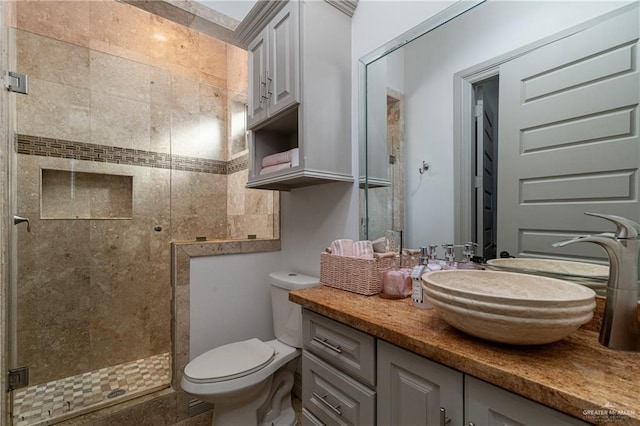 bathroom with a stall shower, vanity, and toilet