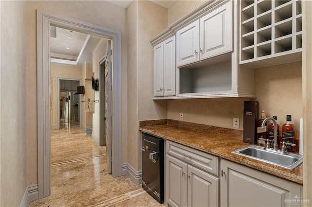 kitchen with a sink, white cabinets, baseboards, dishwasher, and open shelves