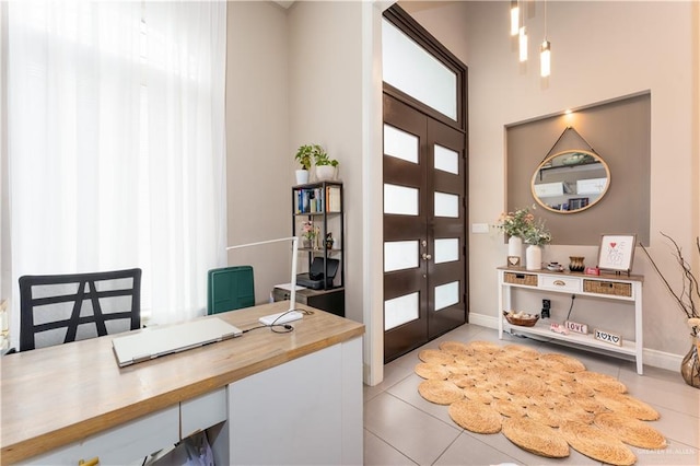 foyer entrance featuring french doors, baseboards, and light tile patterned floors