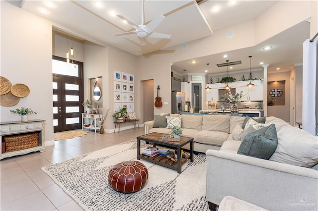 living area with french doors, a high ceiling, a ceiling fan, light tile patterned flooring, and baseboards