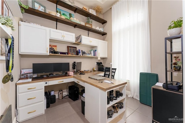 home office with light tile patterned flooring and built in desk