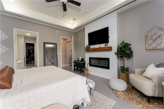 bedroom featuring tile patterned flooring, recessed lighting, a fireplace, visible vents, and a raised ceiling