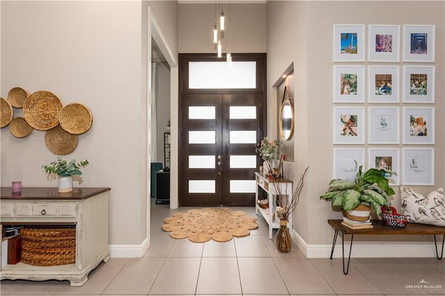 entrance foyer featuring french doors, baseboards, and light tile patterned floors