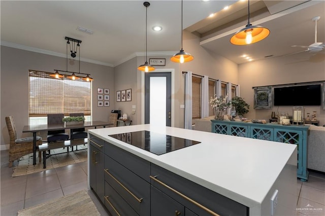 kitchen featuring pendant lighting, light countertops, black electric cooktop, and a center island