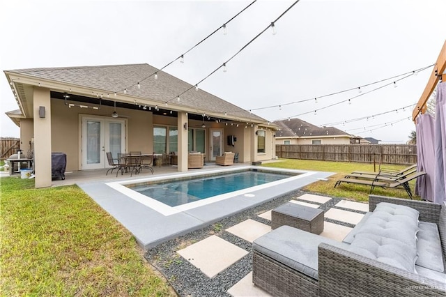 view of swimming pool with a fenced backyard, outdoor lounge area, french doors, a fenced in pool, and a patio area